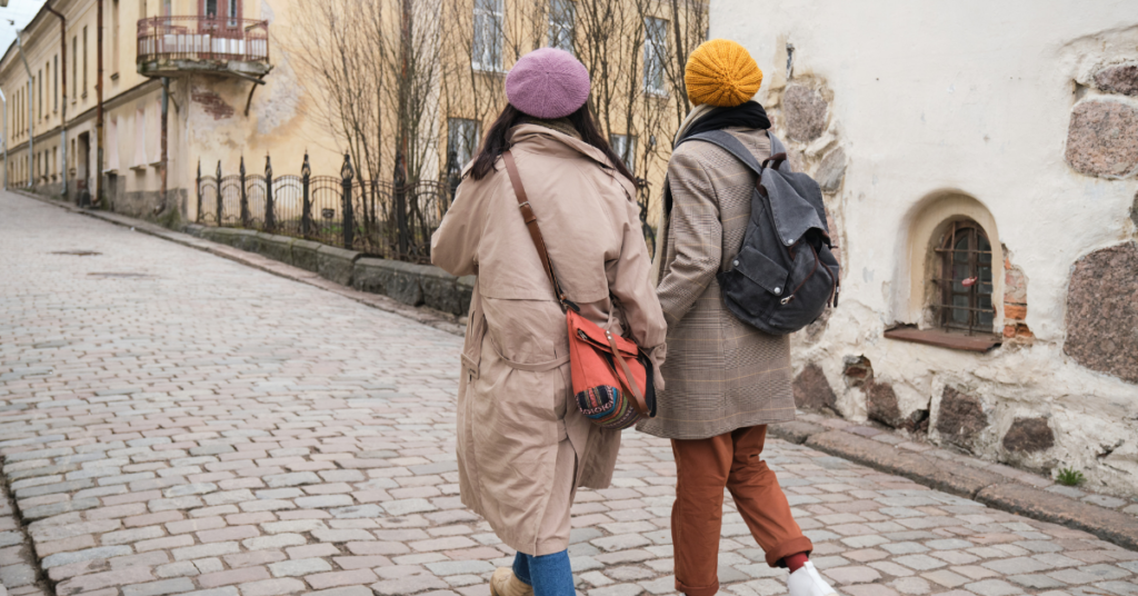 Two woman rugged up walking down a cobblestone street