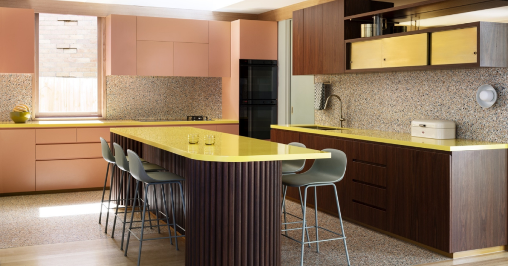 Designer kitchen space with salmon pink and dark wood cupboards and a lime green bench top. By Wowowa architects. 