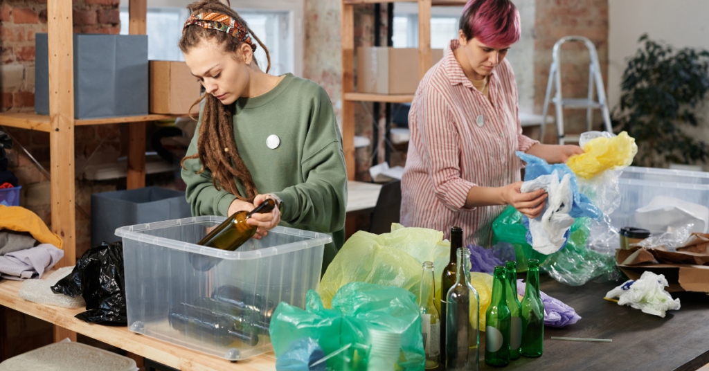 Two people sorting through recycling