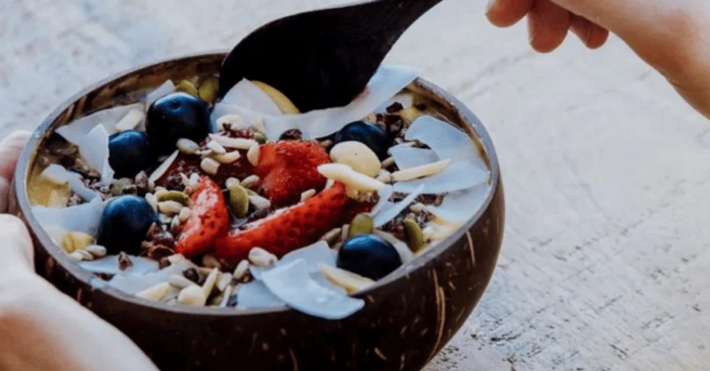 A coconut bowl filled with muesli and fruit
