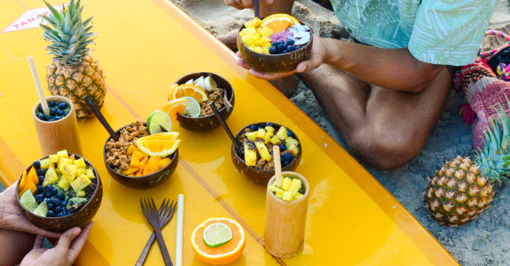 People sitting at a table using coconut bowls
