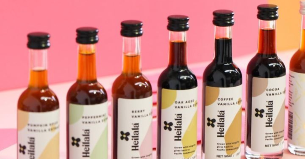 Heilala Vanilla - vanilla extract bottles lined up with pink background