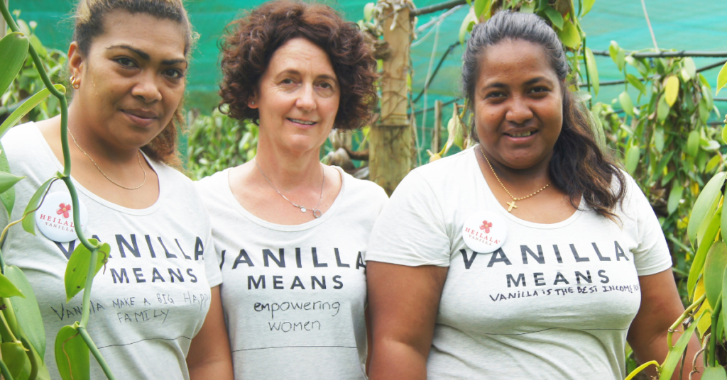 Three people from the Heilala Vanilla team smiling at camera wearing t-shirts that say 'Vanilla means...' 