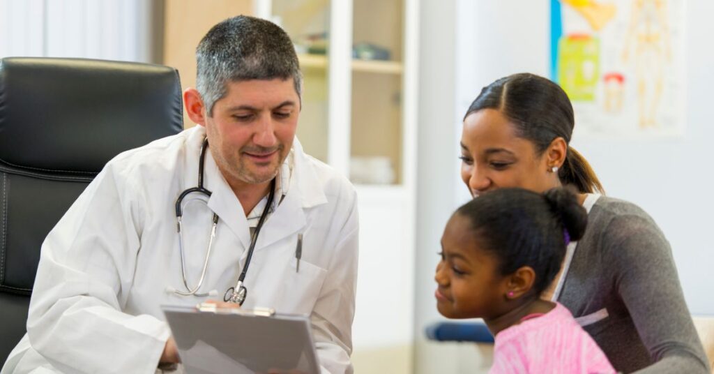 A male doctor talking to a woman and a child
