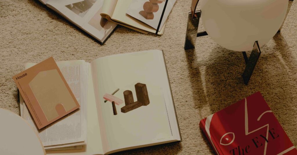 Some design books laying on a cream carpet, displaying NHO's creative process