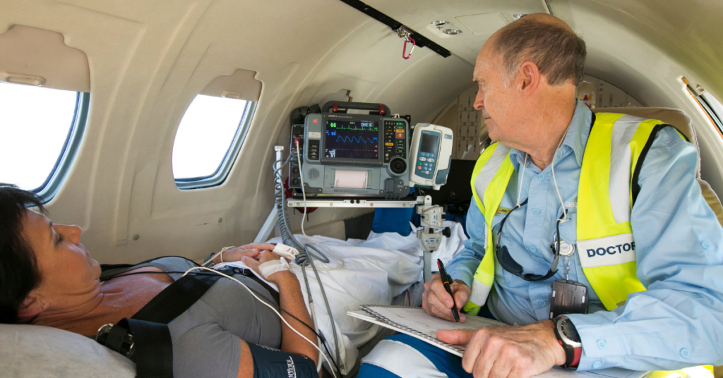 Doctor on a plane with a patient checking vitals