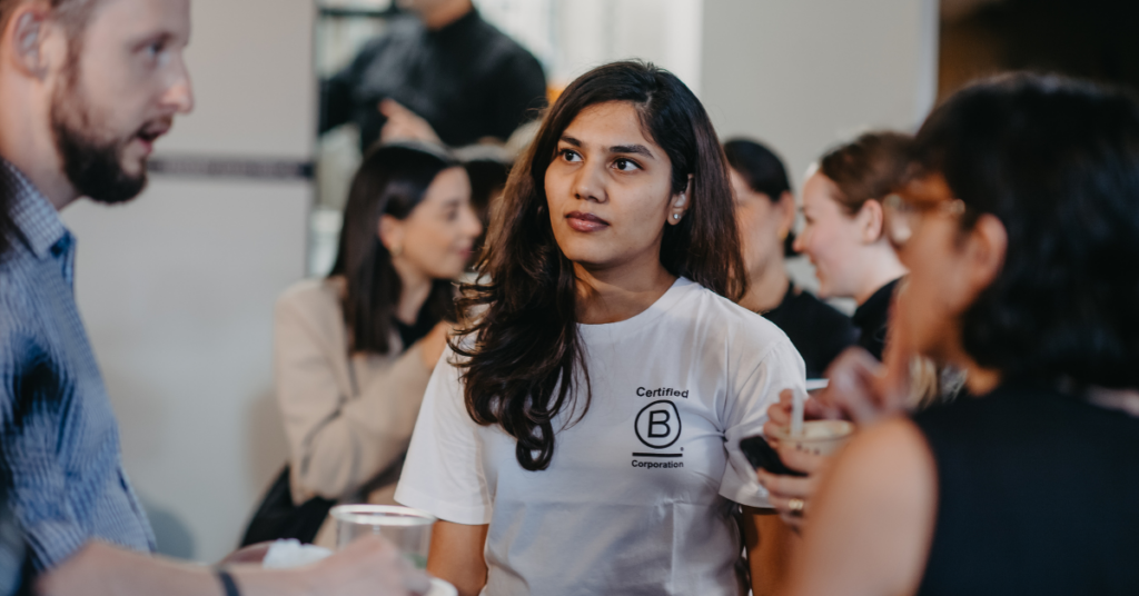 Person wearing white top with the Certified B Corporation logo on it at an event