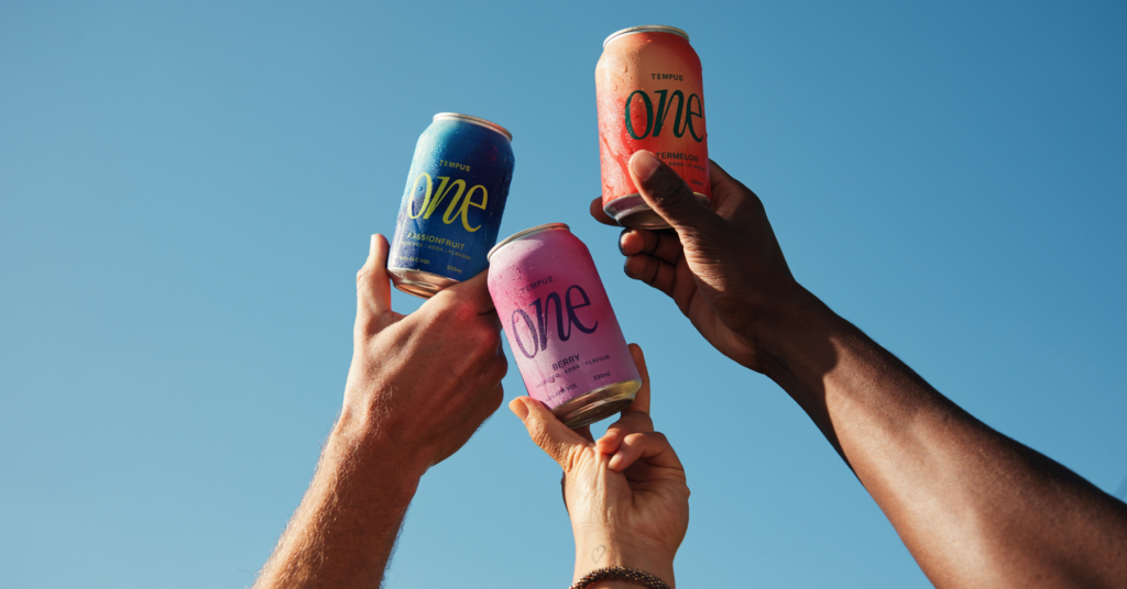 Three hands holding Australian Vintage's Tempus one cans in the air