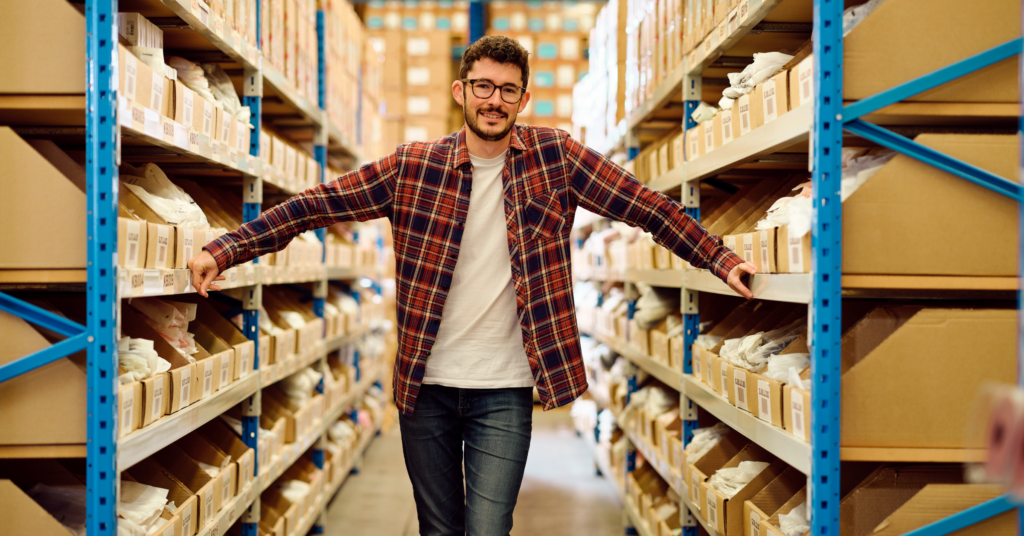 B Corp Starshipit employee standing in front of the warehouse aisle