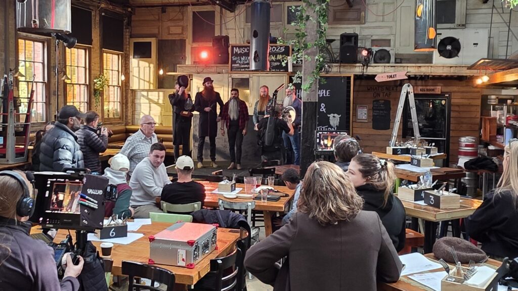 A photo of a film set - videography happening at a small show in a pub