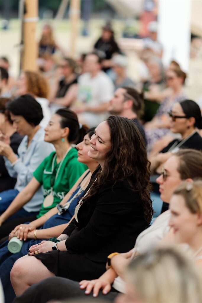 Audience members smiling as they listen to the talks