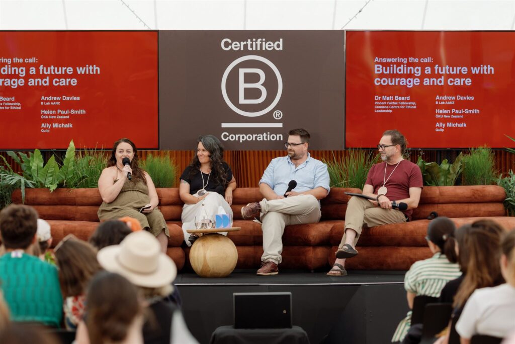 Four panelists sat in front of a B Corp sign, speaking to an audience