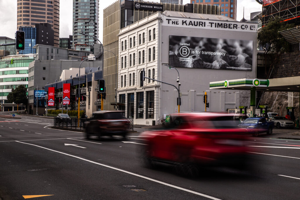 B Corp logo on a billboard with traffic going past