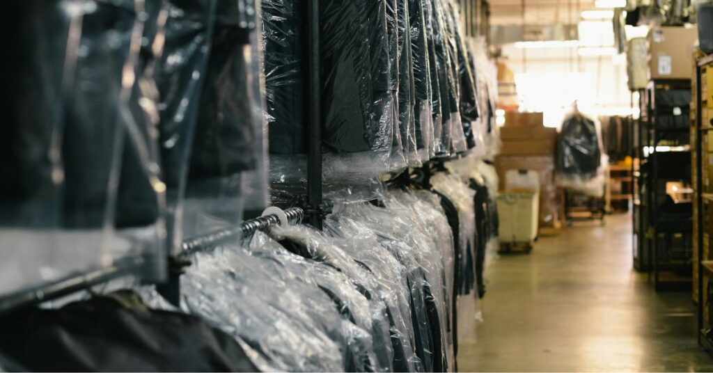 Racks of suits wrapped in plastic bags