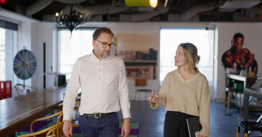 Two people walking and talking in a creative office space.