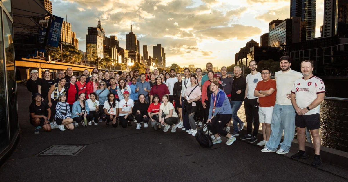 The Intrepid team with the Melbourne skyline behind them at sunset.