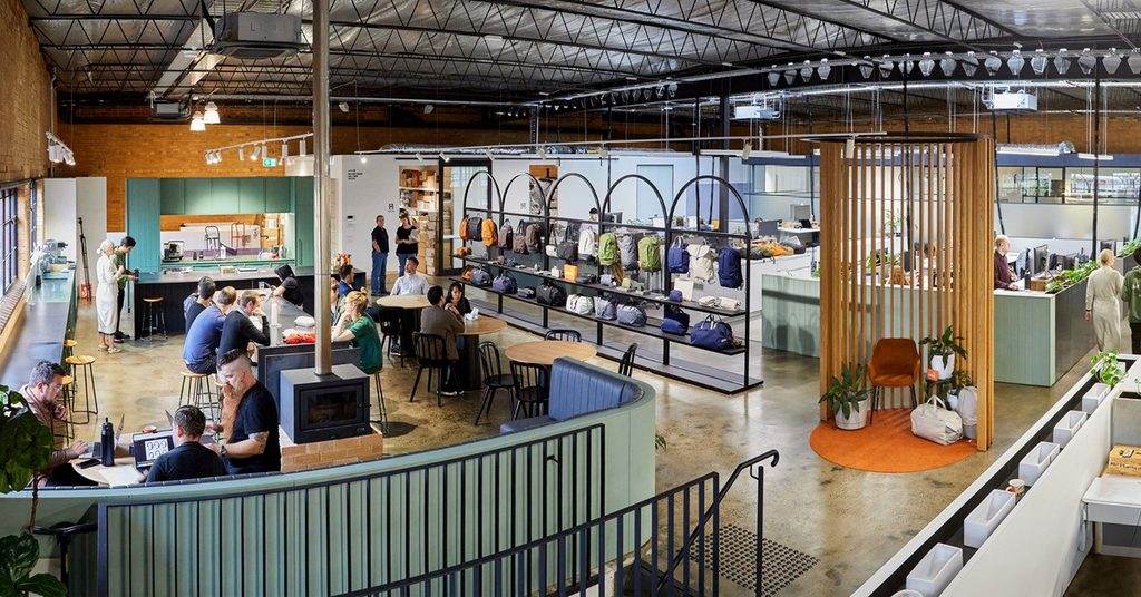 A panoramic shot of the Bellroy office, with people sitting at tables, gear on display, and desks in the background.